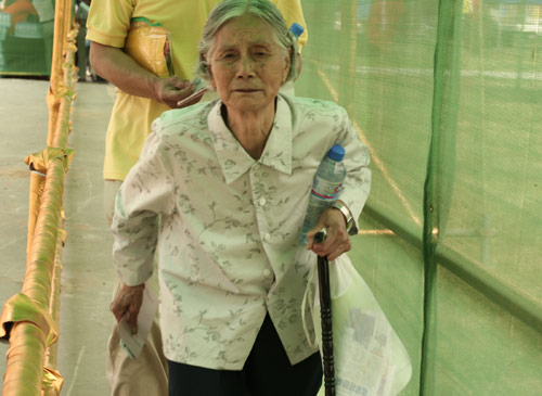 An aged woman waits to cast a vote on the demolishment and reconstruction of old buildings in Juixiaqiao Sub-district in Beijing, June 9, 2007. Local government and the real estate developer jointly organize the vote on Saturday to see if majority residents of over 5000 families accept the new compensation policy after failed attempts to reach an agreement through other ways. Both notary officials and supervisors are invited to monitor the vote that runs from 9 a.m. to 9 p.m. at six ballot booths. [Sun Yuqing/m.orobotics.cn]