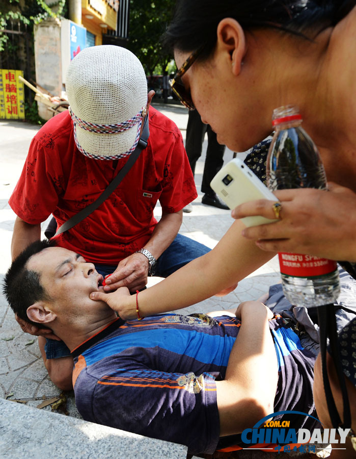 湖北漢口：68歲老人跪地營救暈倒男子