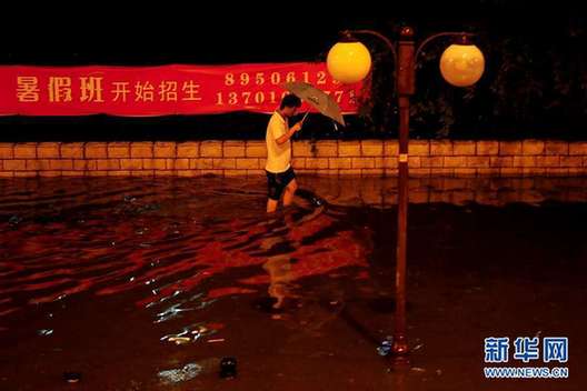 北京夜降暴雨 積水中勇現“淡定哥”(組圖)