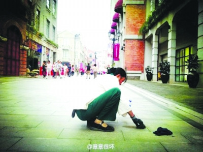 清潔工蹲地鏟口香糖照片走紅 網友呼吁尊重勞動（圖）
