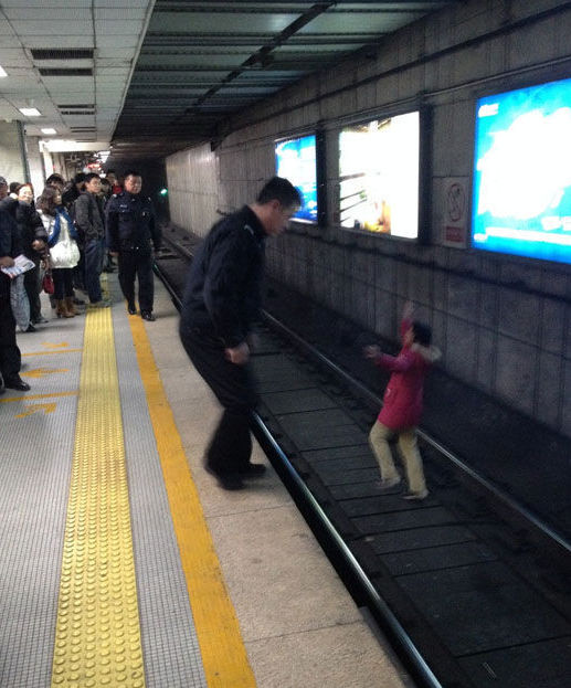 北京一女子地鐵臥軌被強行抱出