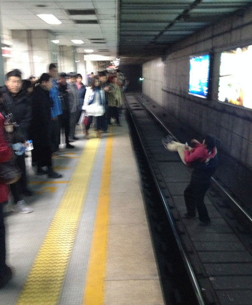 北京一女子地鐵臥軌被強行抱出