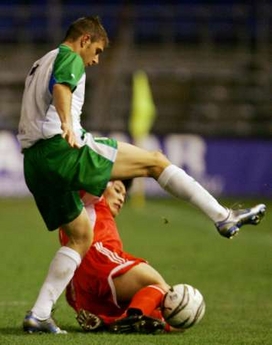 China's Zhang Yao Kun (bottom) challenges Andalucia's Joaquin Sanchez for the ball during their friendly soccer match at the Ramon de Carranza Stadium in Cadiz, southern Spain December 28, 2005.
