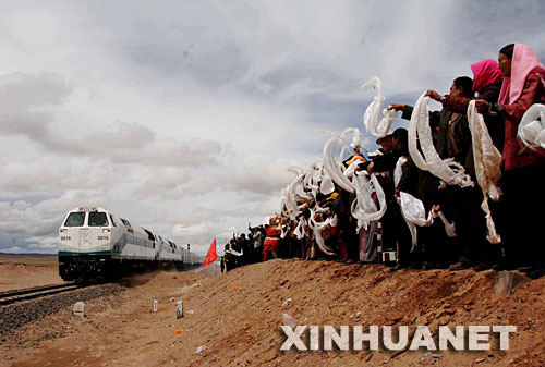 2006年7月1日，青藏鐵路全線通車，標(biāo)志著西藏結(jié)束了不通火車的歷史。青藏鐵路自西寧至拉薩全長(zhǎng)1956公里，包括西寧至格爾木和格爾木至拉薩兩段。這是在位于青海境內(nèi)的沱沱河大橋橋頭，當(dāng)?shù)厝罕姎g迎從格爾木出發(fā)的“青1”次列車（2006年7月1日攝）。 新華社發(fā) 