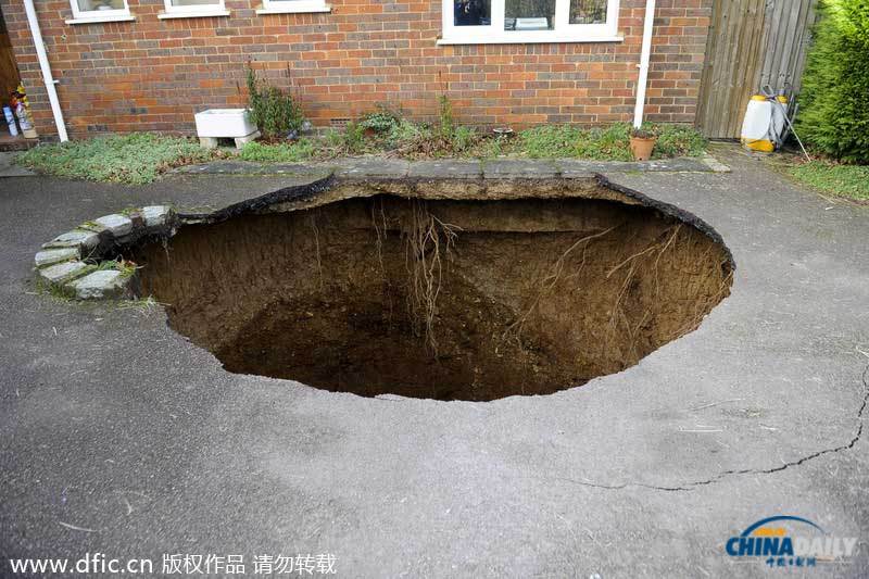 英國居民房屋前驚現大坑 汽車慘遭“吞噬”