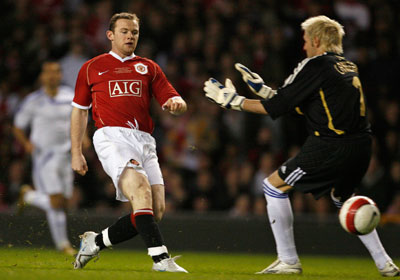 Manchester United's Wayne Rooney (L) scores past Europe XI's Santiago Canizares during a celebration soccer match to mark the 50th anniversary of Manchester United appearing in European competition at Old Trafford in Manchester, northern England, March 13, 2007.
