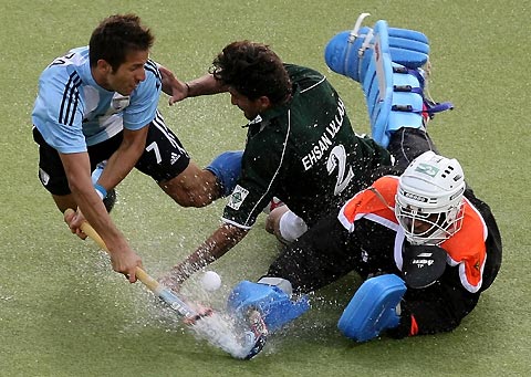 Argentina's Mario Nicolas Almada (L) fights for the ball with Pakistan's Ihsan Ullah (C) and goalkeeper Salman Akbar (R) during their Men's Field Hockey World Cup match at the Warsteiner Hockey Park stadium in Moenchengladbach September 11, 2006. 
